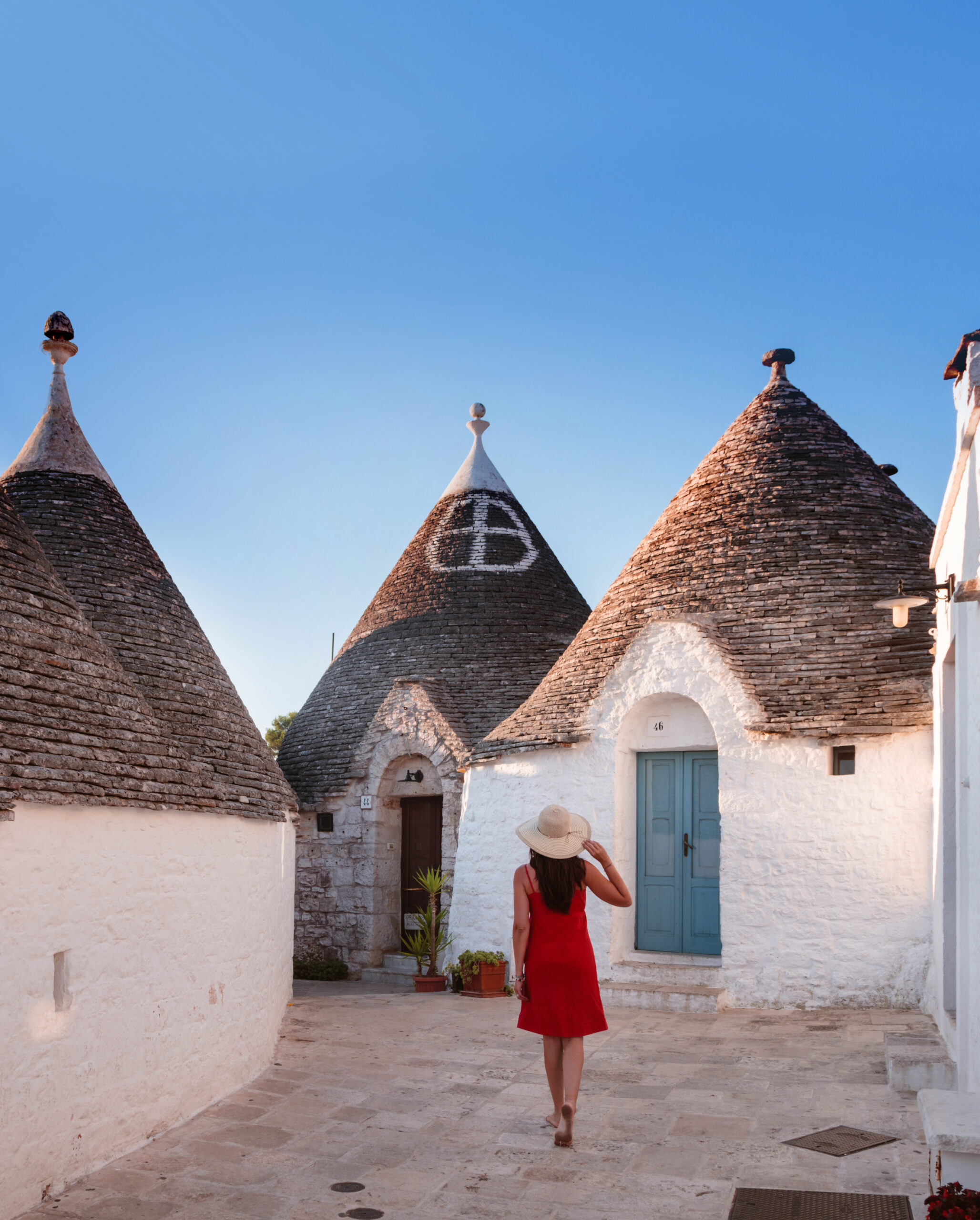 Woman visiting the Trulli area, Alberobello, Itria valley, Apulia, Italy  (MR)